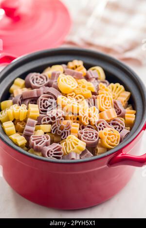 Pasta di varie forme spaventose. Pasta di halloween cruda in pentola. Foto Stock