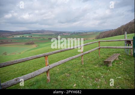 Paesaggio di Odenwald Ronneburg vicino al castello di Ronneburg con recinzione in legno e panca di fronte durante le giornate nuvolose, Germania Foto Stock