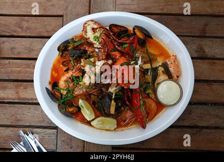 Piatto di pesce alla griglia su tavolo di legno Foto Stock