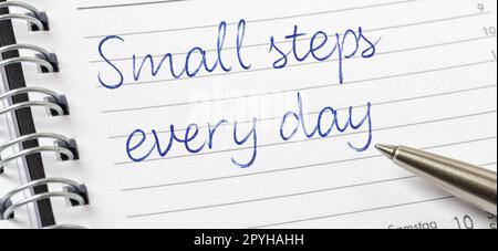 Piccoli passi ogni giorno scritti su una pagina del calendario Foto Stock