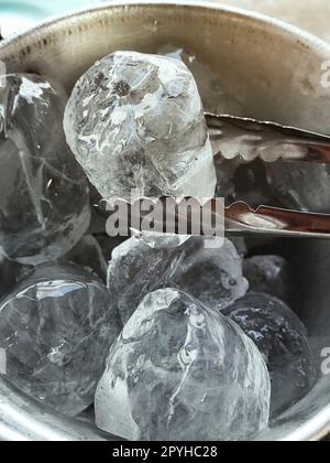 Secchiello per ghiaccio con pinze per tenere le mani Foto Stock