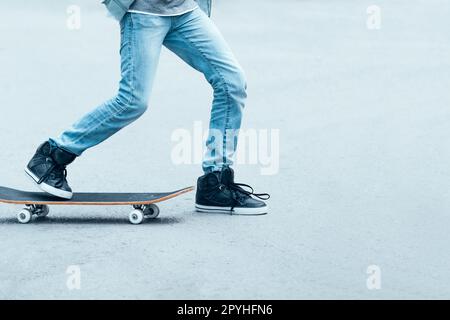 Ragazzo adolescente che cavalca sullo skateboard Foto Stock