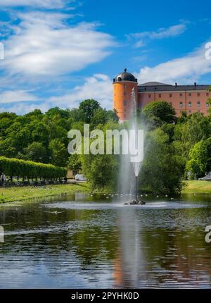 Una fontana in un parco di fronte ad un vecchio edificio Foto Stock