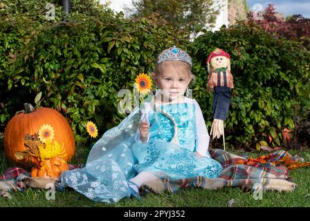 Carina ragazza caucasica vestita come una principessa con tiara. il bambino finge di giocare. Costume di Halloween bambini Foto Stock