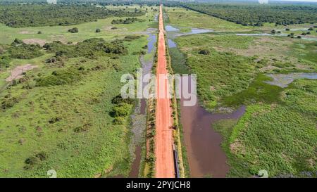 Veduta aerea della strada sterrata di Transpantaneira che attraversa direttamente il tipico paesaggio delle paludi di Pantanal Nord, Mato Grosso, Brasile Foto Stock