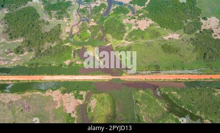 Veduta aerea della strada sterrata di Transpantaneira che attraversa il tipico paesaggio delle paludi Pantanal con lagune, fiumi, prati e foreste, Mato Grosso, Brasile Foto Stock