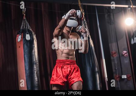 I boxer professionisti indossano cuffie per la realtà virtuale per partecipare a coinvolgenti simulazioni di allenamenti di boxe mentre si esercitano sulle tecniche di punzonatura. Dal vivo, Foto Stock