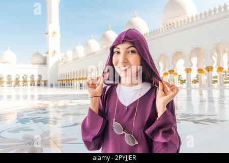 La serenità della Grande Moschea Sheikh Zayed è accresciuta dalla presenza di una ragazza turistica nella sua modesta Abaya. Foto Stock