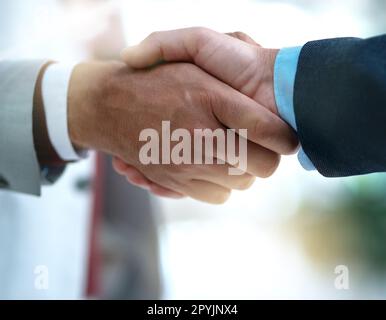 Bene faccia le cose grandi insieme. Due uomini d'affari irriconoscibili che scuotono le mani dopo aver fatto un affare nell'ufficio. Foto Stock