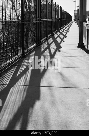 Ombra ringhiera sul ponte. La ringhiera del ponte proietta un'ombra. Ponte astratto ringhiera ombra. Scena urbana, foto di strada, nessuno Foto Stock