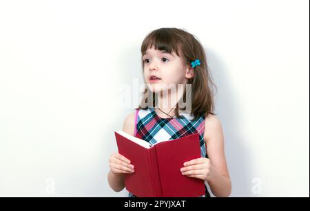 Bambina la lettura di un libro a casa Foto Stock