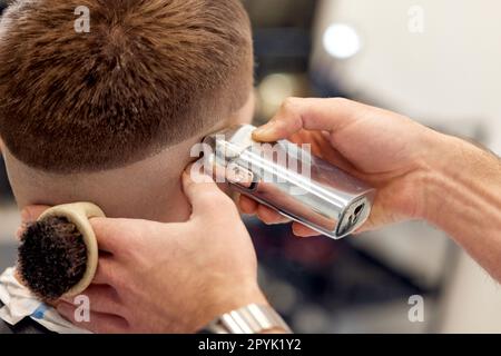 Parrucchiere con rifinitore su bell'uomo bearded Foto Stock