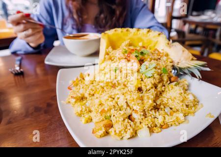 Questo piatto di riso e ananas tailandese è una sinfonia di sapori dolci e salati che ballano attraverso la lingua. L'ananas succoso e piccante si abbina perfettamente Foto Stock