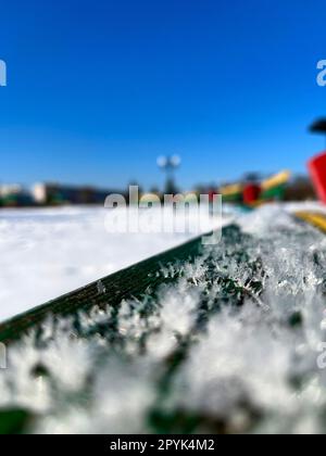 panchine colorate sotto la neve in inverno sul terrapieno Foto Stock