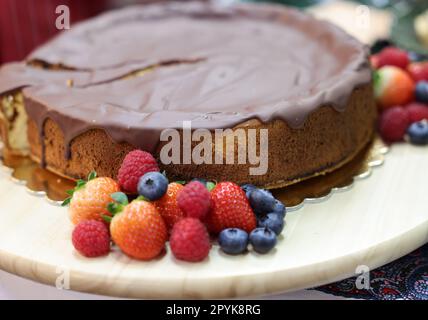 Torta di Spagna con glassa al cioccolato e frutta fresca Foto Stock