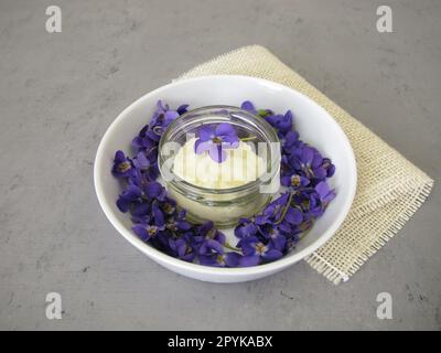 Deodorante solido fatto in casa con dolce profumo di viola in un vaso di vetro Foto Stock