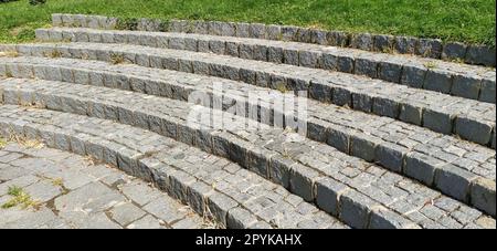 Gradini semicircolari dell'anfiteatro. Ampia scala in blocchi di pietra o mattoni. Mattoni irregolari. I vecchi passi sono circolari Foto Stock