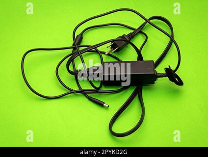 Caricabatteria del computer su sfondo verde Foto Stock
