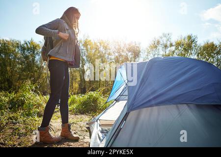 Shes allontanandosi da tutto. una giovane donna attraente seduta nel suo campeggio. Foto Stock