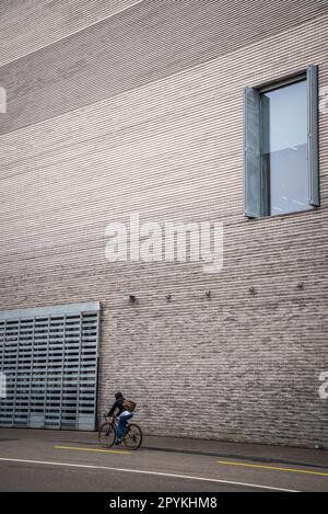 Il ciclista passa dal Museo di Arte Contemporanea, nuova estensione costruita nel 2016, parte del Kunstmuseum Basilea, Basilea, Svizzera Foto Stock