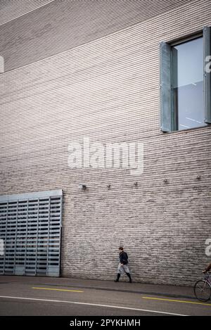 Persona che passa dal Museo di Arte Contemporanea nuova estensione costruita nel 2016, parte del Kunstmuseum Basilea, Basilea, Svizzera Foto Stock