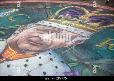 Con l'avvicinarsi del giorno dell'incoronazione, un artista dipinge magistralmente Re Carlo III sul terreno. Foto Stock