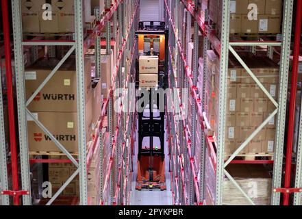 04 maggio 2023, Baden-Württemberg, Künzelsau: Un dipendente del Gruppo Würth trasporta un pallet su un carrello elevatore in una corsia di un magazzino ad alto piazzale. Il Gruppo Würth presenta il bilancio annuale in occasione di una conferenza stampa e fornisce le prospettive per l'esercizio in corso. Foto: Marijan Murat/dpa Foto Stock