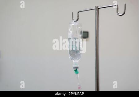 Borsa IV appesa ad un palo metallico nella stanza dell'ospedale Foto Stock