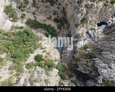 Cascata che scorre attraverso la zona di pietra e ha quasi alcuna acqua. Foto Stock