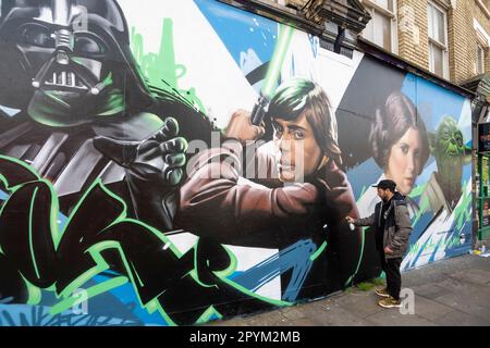 Londra, Regno Unito. 4 maggio 2023. L'artista di strada Nacho Welles aggiunge un tocco finale al suo nuovo murale ispirato alle Guerre Stellari a Shoreditch in quello che è diventato noto come "Star Wars Day". I fan di Star Wars hanno notato che la prima parte della frase del film “maggio la forza è con te” suona come “maggio il quarto”, così il 4 maggio è diventato la scelta ovvia per celebrare la serie. Credit: Stephen Chung / Alamy Live News Foto Stock