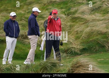 L'ex presidente degli Stati Uniti Donald Trump punta verso i media mentre gioca a golf al Trump International Golf Links & Hotel di Doonbeg, Co. Clare, durante la sua visita in Irlanda. Data immagine: Giovedì 4 maggio 2023. Foto Stock