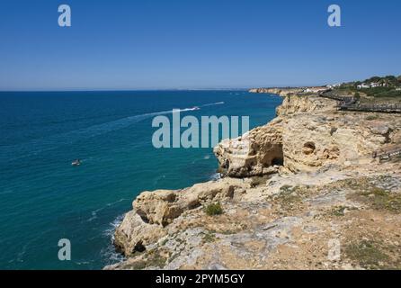 Carvoeiro, Portogallo - 11 aprile 2023: Paesaggi meravigliosi in Portogallo. Vista panoramica e colorata della costa di Carvoeiro nella regione dell'Algarve. Roccia gialla Foto Stock