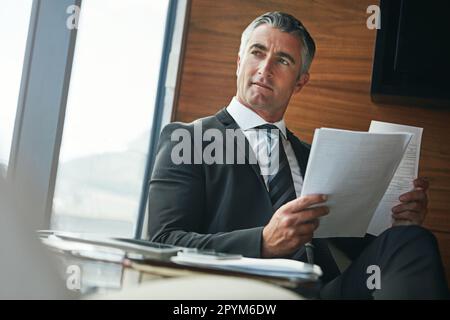 Si concentra sulle soluzioni, non sui problemi. un uomo d'affari maturo che passa attraverso la documentazione sul lavoro. Foto Stock