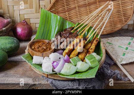 Il pollo alla griglia e il satay di manzo, mangiato con salsa di arachidi, sono famosi piatti locali malesi e indonesiani Foto Stock