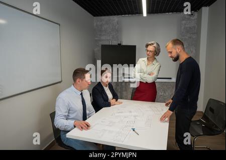 L'estrusione femminile valuta il lavoro dei subordinati. Progettisti ingegneri a una riunione. Foto Stock