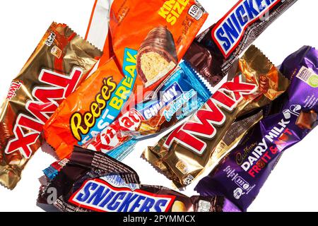 Ho Chi Minh City, Vietnam - 2 maggio 2023: Involucri vuoti con loghi di caramelle al cioccolato popolare, Twix, Snickers, KitKat, Cadbury, Reeses, isolato Foto Stock