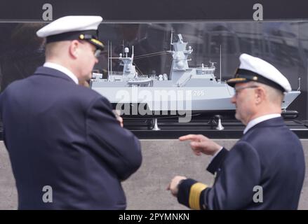 Amburgo, Germania. 04th maggio, 2023. Due membri della Marina si trovano di fronte ad un modello della corvette F 265 'Cologne' prima della cerimonia di nomina della corvette F 266 'Emden' presso il cantiere navale Blohm Voss nel porto. Circa sei anni dopo l'ordine di costruzione, la seconda delle cinque nuove navi navali viene battezzata. La corvette della Marina tedesca è ufficialmente chiamata 'Emden'. Tutte e cinque le nuove cornici sono in costruzione in diversi cantieri navali della Germania settentrionale sotto la direzione del Gruppo NVL. Credit: Marcus Brandt/dpa/Alamy Live News Foto Stock