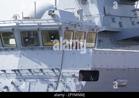 Amburgo, Germania. 04th maggio, 2023. Un lavoratore del cantiere navale si trova sul ponte accanto al ponte della corvette F266 'Emden', secondo di un totale di cinque nuove navi per la Marina, sulla banchina del cantiere navale Blohm Voss nel porto. Circa sei anni dopo l'ordine di costruzione, la seconda delle cinque nuove navi navali viene battezzata. La corvette della Marina tedesca è ufficialmente chiamata 'Emden'. Tutte e cinque le nuove cornici sono state costruite sotto la gestione del gruppo NVL in diversi cantieri navali della Germania settentrionale. Credit: Marcus Brandt/dpa/Alamy Live News Foto Stock