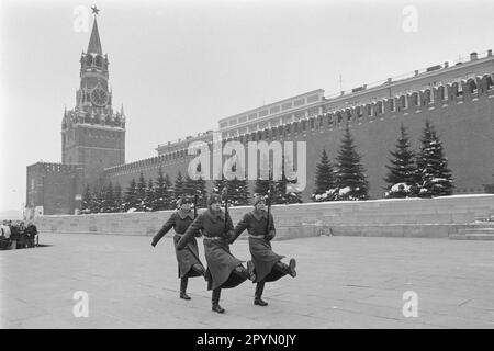 1985: Poco prima delle 12, secondo l'orologio della Torre Spassky del Cremlino, una folla guarda il cambio della guardia d'onore al mausoleo di Lenin appena fuori dalle mura del Cremlino in Piazza Rossa, Mosca, 1985. Il presidente Boris Eltsin ha rimosso la guardia d'onore nell'ottobre 1993. Foto Stock