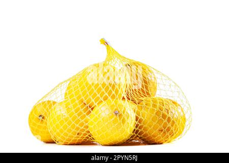 Gruppo di ripe di limoni in una borsa a rete contro uno sfondo bianco Foto Stock