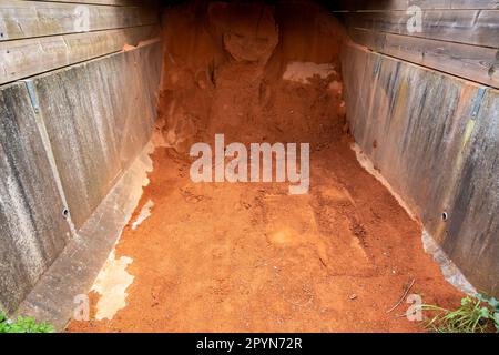 Ghiaia rossa per campo da tennis superficie fatta di mattoni schiacciati, pietra o scisto mescolato con sabbia immagazzinata sotto riparo di legno, Paesi Bassi Foto Stock