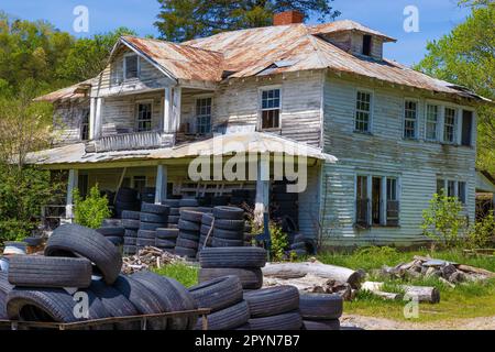 Un decadente cantiere di casa vacante a due piani serve come un'area di deposito pneumatici nel North Carolina. Foto Stock