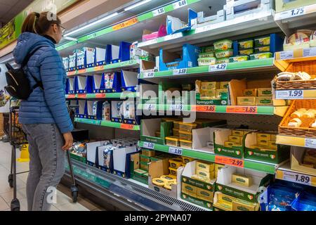 Clonakilty, West Cork, Irlanda. 4th maggio, 2023. I supermercati Aldi, Lidl, Tesco e SUPERVALU hanno tagliato i prezzi del latte e del burro negli ultimi giorni, cosa che secondo gli agricoltori rappresenta un altro colpo per l'industria lattiero-casearia. Una donna controlla i prezzi del burro scontato nel supermercato Lidl, Clonakilty. Credit: AG News/Alamy Live News Foto Stock