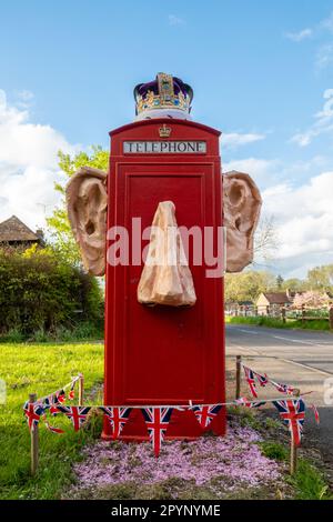 Maggio 4th 2023. Un divertente phonebox decorato un paio di giorni prima dell'incoronazione del re Carlo III e della regina Camilla. Le decorazioni irriverenti nel villaggio Surrey di Compton, Inghilterra, Regno Unito, includono grandi orecchie sporgenti e naso con una corona. Foto Stock