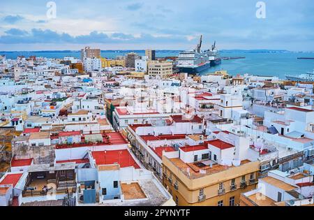 La vista dal campanile della Cattedrale sui tetti della città, il porto, navi da crociera, navi da carico, gru e monumenti storici, Cadice, Spagna Foto Stock