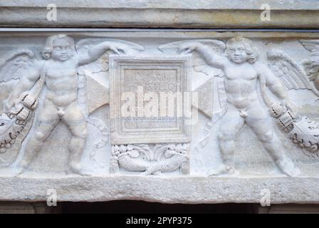 Una parete che presenta statue multiple con varie in una disposizione decorativa Foto Stock