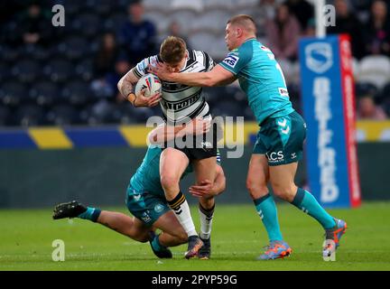 Il Liam Sutcliffe del Hull FC è affrontato dalla Morgan Smithies (a destra) dei Guerrieri Wigan durante la partita della Betfred Super League al MKM Stadium di Hull. Data immagine: Giovedì 4 maggio 2023. Foto Stock