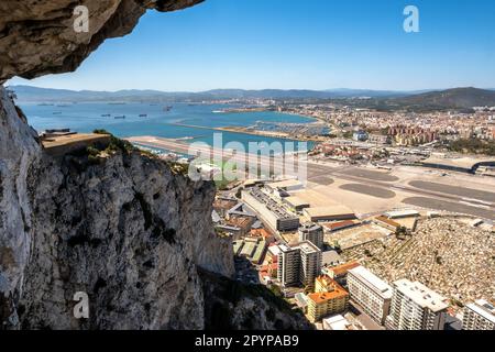 Gibraltar International Airport visto dai tunnel del Grande Assedio nella Rocca di Gibraltar; Algeciras, Spagna, in lontananza Foto Stock