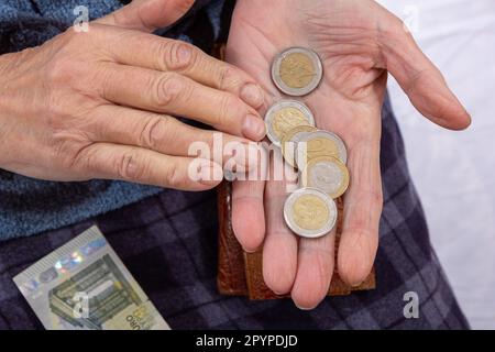 monete in euro in mani alte Foto Stock