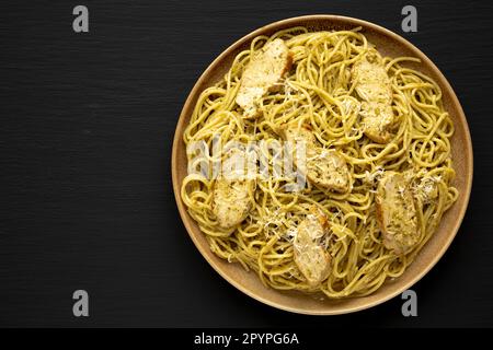 Pesto alla Genovese fatto in casa Pasta su un piatto su sfondo nero, vista dall'alto. Giacitura piana, sovratesta, dall'alto. Spazio per il testo. Foto Stock